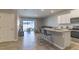 Open-concept living room and modern kitchen with tile floors and sliding glass doors to the outdoor patio at 2801 Midnight Pearl Dr, Sarasota, FL 34240