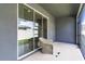 View of the screened patio with a chair and sliding glass door to the interior at 2801 Midnight Pearl Dr, Sarasota, FL 34240