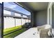 View of the screened patio with a chair and a glimpse of the fenced backyard at 2801 Midnight Pearl Dr, Sarasota, FL 34240