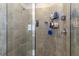 Shower features neutral tile, glass door, and built-in and hanging storage for toiletries at 2801 Midnight Pearl Dr, Sarasota, FL 34240