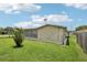 Exterior of home featuring a sunroom with ample windows and a spacious, grassy backyard at 3401 Pinon Dr, Holiday, FL 34691