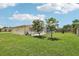 Large backyard with lush green grass, mature trees, and a glimpse of the home's exterior at 3401 Pinon Dr, Holiday, FL 34691