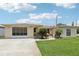 Charming single-story home with lush landscaping, a driveway, and a screened-in garage in a well-maintained community at 3401 Pinon Dr, Holiday, FL 34691