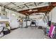Tiled garage with overhead lighting, stove, shelving, doors, and ceiling fan at 3401 Pinon Dr, Holiday, FL 34691