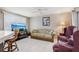 Bright living room featuring a white brick wall and comfortable seating area, complete with a ceiling fan at 3401 Pinon Dr, Holiday, FL 34691