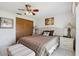Bright bedroom with tiled floors, ceiling fan, art, lamps, bench, and closet at 3401 Pinon Dr, Holiday, FL 34691
