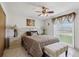 Bright bedroom with tiled floors, ceiling fan, art, lamps, and bench at 3401 Pinon Dr, Holiday, FL 34691
