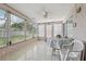 Light and bright sunroom with tiled floors, ceiling fan and windows with view of fenced yard at 3401 Pinon Dr, Holiday, FL 34691