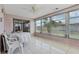 Sunroom boasts tiled floors, multiple windows and doors, and ceiling fan at 3401 Pinon Dr, Holiday, FL 34691