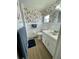 Bright bathroom features a single sink vanity, decorative wall paper, and a window for natural light at 34091 Alamanda N Dr, Pinellas Park, FL 33781