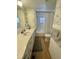 Bathroom with large vanity, shower with tub, and gray and white wallpaper at 34091 Alamanda N Dr, Pinellas Park, FL 33781