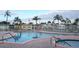 Community pool with lounge chairs, palm trees, clear blue water, and a spa in a retirement community at 34091 Alamanda N Dr, Pinellas Park, FL 33781