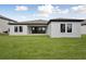 Back exterior featuring a lush green lawn, and a covered patio with sliding glass doors at 3448 Yellow Leaf Cir, Spring Hill, FL 34609