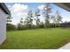 Spacious backyard with an iron fence and a view of the surrounding trees and landscape at 3448 Yellow Leaf Cir, Spring Hill, FL 34609