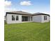 The backyard features a lush green lawn and a covered patio with sliding glass doors at 3448 Yellow Leaf Cir, Spring Hill, FL 34609