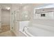 Bright bathroom with a soaking tub, tiled shower, and walk-in closet at 3448 Yellow Leaf Cir, Spring Hill, FL 34609