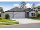 Charming single-story house featuring a manicured lawn and a three-car garage at 3448 Yellow Leaf Cir, Spring Hill, FL 34609