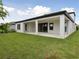 A covered back patio overlooks a lawn area featuring sliding glass doors and exterior access door at 3458 Yellow Leaf Cir, Spring Hill, FL 34609