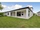 This home features a covered patio and a spacious backyard with a lush, green lawn at 3458 Yellow Leaf Cir, Spring Hill, FL 34609