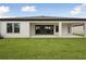 The backyard features a covered patio, sliding glass doors, and a well-manicured lawn at 3458 Yellow Leaf Cir, Spring Hill, FL 34609