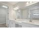 Elegant bathroom featuring dual sinks with white countertops and a large mirror at 3458 Yellow Leaf Cir, Spring Hill, FL 34609