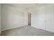A well-lit bedroom featuring neutral carpeting, white walls, and a double door closet at 3458 Yellow Leaf Cir, Spring Hill, FL 34609