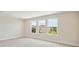 Bedroom with three windows offering exterior views and neutral carpeting at 3458 Yellow Leaf Cir, Spring Hill, FL 34609