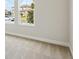 A bedroom with neutral carpet and trim, featuring a window with a view of the neighborhood at 3458 Yellow Leaf Cir, Spring Hill, FL 34609