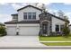 This two-story home has a stone-accented entrance, a three-car garage, and manicured landscaping at 3458 Yellow Leaf Cir, Spring Hill, FL 34609