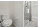 Modern bathroom with a toilet and tiled shower, featuring glass doors and neutral fixtures at 3762 Mossy Limb Ct, Palmetto, FL 34221
