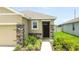 Close-up view of home's entrance featuring stone accents, neutral paint, and manicured landscaping at 3762 Mossy Limb Ct, Palmetto, FL 34221