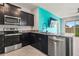 Modern kitchen featuring dark cabinets, stainless steel appliances, granite countertops, and an open layout at 3762 Mossy Limb Ct, Palmetto, FL 34221
