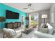 Comfortable living room with stylish furniture, a large TV, and a sliding glass door to the backyard, perfect for relaxation at 3762 Mossy Limb Ct, Palmetto, FL 34221