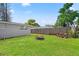 Picture of a backyard with green lawn, stone fire pit, wooden fence and mature trees at 4922 Bola St, New Port Richey, FL 34652
