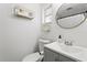 Neat bathroom featuring a white toilet, sink with vanity, and round mirror with modern fixtures at 4922 Bola St, New Port Richey, FL 34652