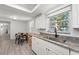 Bright kitchen with stainless steel sink, granite countertops, and dining area with table and chairs at 4922 Bola St, New Port Richey, FL 34652