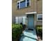 Inviting condo entrance with a teal door, awning, and well-manicured landscaping at 5247 81St N St # 2, St Petersburg, FL 33709