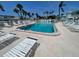 Sparkling community pool surrounded by lounge chairs and tropical landscaping at 5247 81St N St # 2, St Petersburg, FL 33709