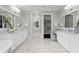 Large bathroom with double vanity, marble counters, and a walk-in closet nearby and a glass enclosed shower at 534 Ladrone Ave, Tampa, FL 33606