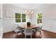 Cozy dining room features a round table, wainscotting, dark hardwood floors, neutral decor, and bright windows at 534 Ladrone Ave, Tampa, FL 33606