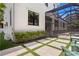 Exterior view of a screened-in pool and patio area with lush greenery and stylish outdoor seating at 534 Ladrone Ave, Tampa, FL 33606