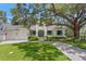 Picturesque two-story home exterior with a well-manicured lawn, mature trees, and a three-car garage at 534 Ladrone Ave, Tampa, FL 33606