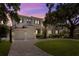 Inviting home exterior at dusk, featuring a well-manicured lawn, mature trees, and a three-car garage at 534 Ladrone Ave, Tampa, FL 33606