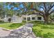 Charming home exterior with a lush front lawn, mature trees, and a three-car garage at 534 Ladrone Ave, Tampa, FL 33606