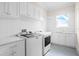 Well-lit laundry room featuring white cabinets, modern washer and dryer, and bright countertop space at 534 Ladrone Ave, Tampa, FL 33606