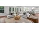 Open concept living room leads to a modern kitchen featuring hardwood floors, neutral decor, and lots of windows at 534 Ladrone Ave, Tampa, FL 33606