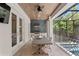 This screened outdoor kitchen and dining area features a built-in grill, tile flooring and beautiful wood ceiling at 534 Ladrone Ave, Tampa, FL 33606