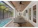 Outdoor patio overlooking the pool, dining table, ceiling fans, and wood ceiling at 534 Ladrone Ave, Tampa, FL 33606