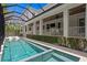 Relaxing pool with a connected jacuzzi, screened-in lanai, travertine tile decking, and privacy landscaping at 534 Ladrone Ave, Tampa, FL 33606