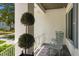 Welcoming front porch with gray chairs and a manicured decorative tree at 534 Ladrone Ave, Tampa, FL 33606